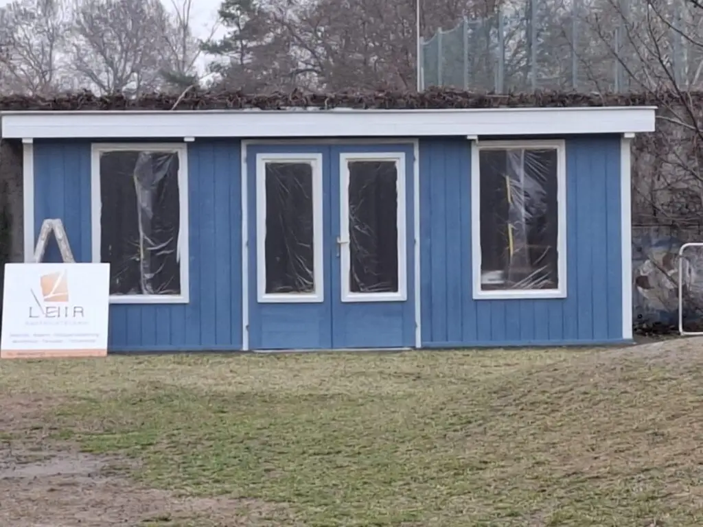 Holzfassade eines Gartenhauses nach dem Anstrich